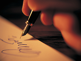 close up of hand signing a paper